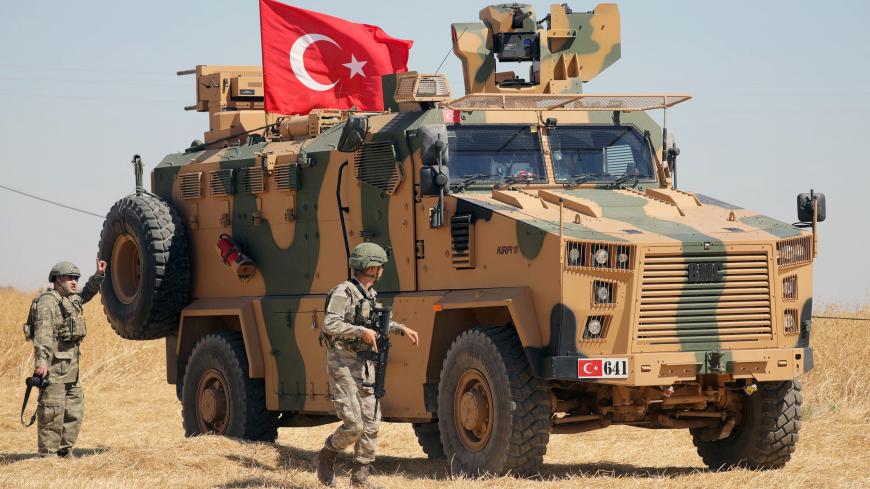 A Turkish soldier walks next to a Turkish military vehicle during a joint U.S.-Turkey patrol, near Tel Abyad, Syria September 8, 2019. REUTERS/Rodi Said - RC1CFC59FD70
