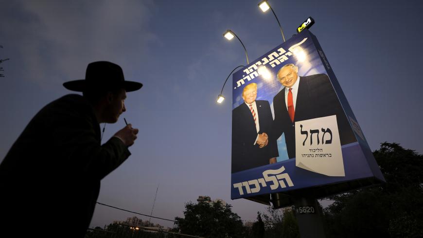 An ultra-Orthodox Jewish man walks past a Likud party election campaign banner depicting Israeli Prime Minister Benjamin Netanyahu and U.S. President Donald Trump in Jerusalem September 11, 2019. REUTERS/Ammar Awad - RC18D246D580