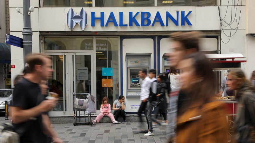 People walk past by a branch of Halkbank in central Istanbul, Turkey, October 16, 2019. REUTERS/Huseyin Aldemir - RC1BA1A70200