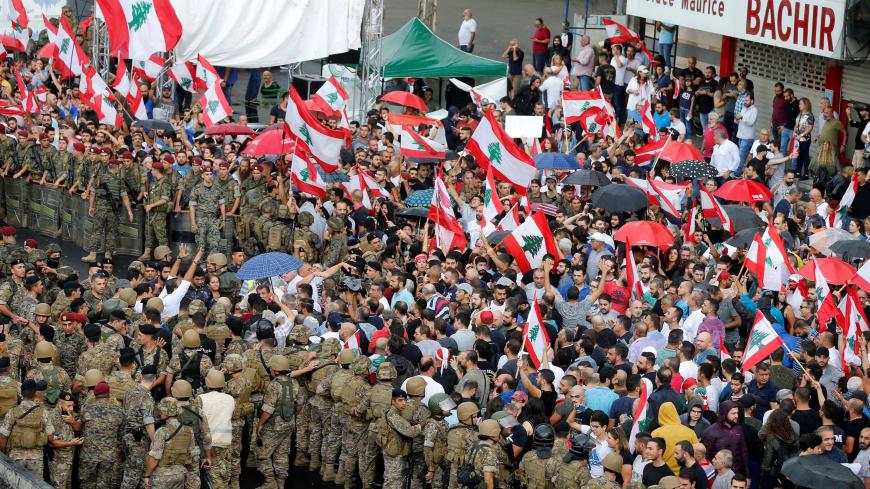 Demonstrators carry Lebanese flags during ongoing anti-government protests at a highway in Jal el-Dib, Lebanon October 23, 2019. REUTERS/Mohamed Azakir - RC16EC6EC900