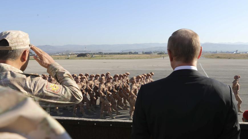Russian President Vladimir Putin (R) and Defence Minister Sergei Shoigu watch servicemen passing by as they visit the Hmeymim air base in Latakia Province, Syria December 11, 2017.  Sputnik/Mikhail Klimentyev/Sputnik via REUTERS  ATTENTION EDITORS - THIS IMAGE WAS PROVIDED BY A THIRD PARTY. - UP1EDCB15ZA3V