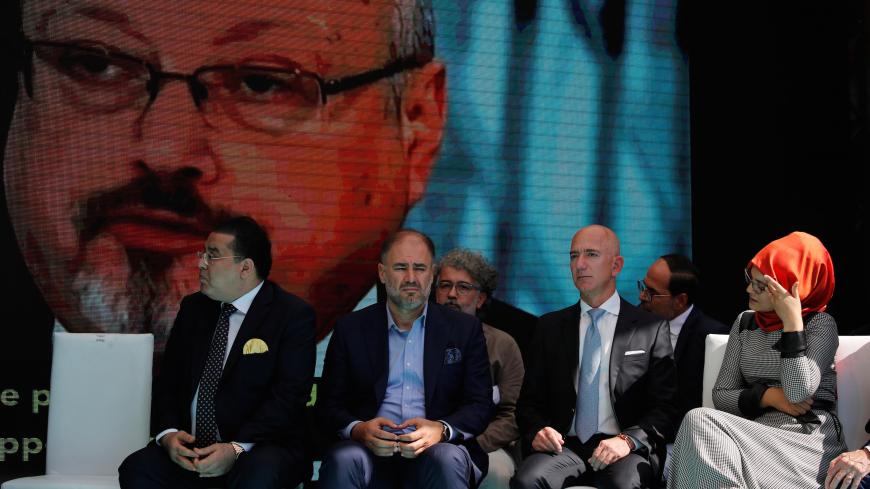 Hatice Cengiz, fiancee of the murdered Saudi journalist Jamal Khashoggi, and Jeff Bezos, founder of Amazon and Blue Origin, are flanked by attendees as they attend a ceremony marking the first anniversary of Khashoggi's killing at the Saudi Consulate in Istanbul, Turkey, October 2, 2019. REUTERS/Umit Bektas - RC15DF9D2FB0