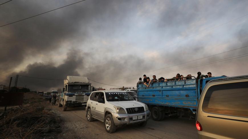 People stand at a back of a truck as they flee Ras al Ain town, Syria October 9, 2019. REUTERS/Rodi Said - RC161F591340