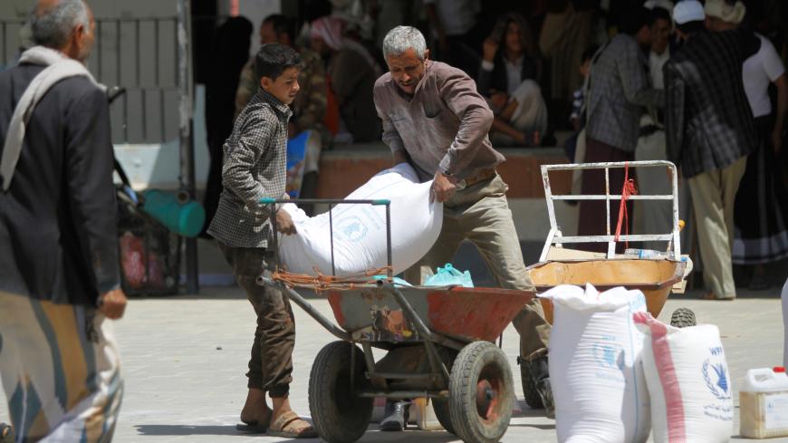 Workers carry the aid provided by the World Food Programme (WFP) for distribution in Sanaa, Yemen August 21, 2019. REUTERS/Mohamed al-Sayaghi - RC1E3E8CE770