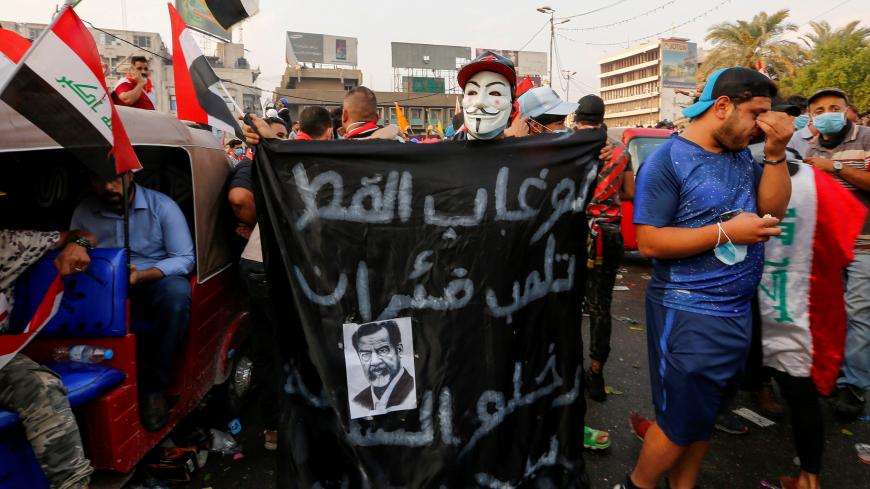 A demonstrator wears a mask as he carries a sign with a picture of former Iraqi president Saddam Hussein during a protest over corruption, lack of jobs, and poor services, in Baghdad, Iraq October 29, 2019. REUTERS/Wissm al-Okili REFILE - ADDING INFORMATION - RC1E4D782810