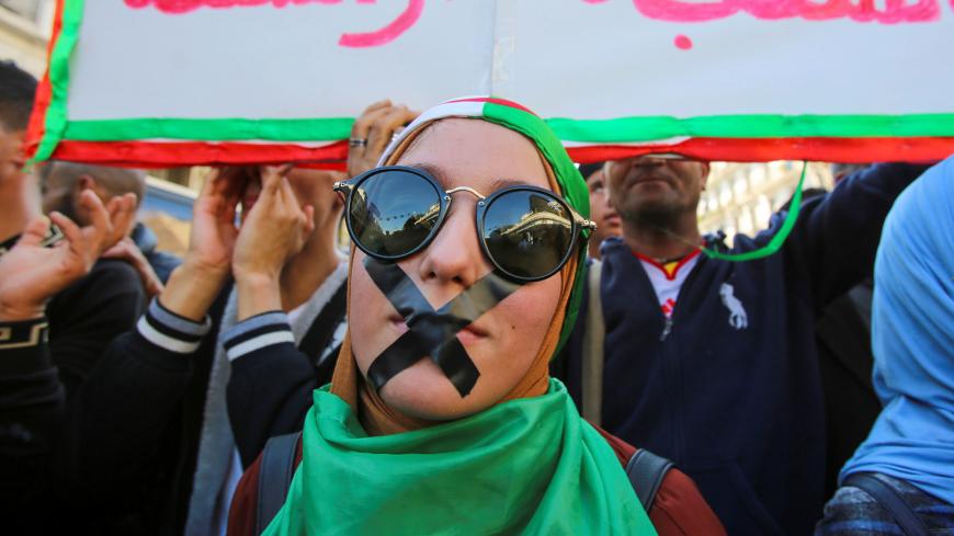 A demonstrator with tapes over her mouth takes part in a protest against the country's ruling elite and to demand an end to corruption and the army's withdrawal from politics in Algiers, Algeria October 29, 2019. Picture taken October 29, 2019. REUTERS/Ramzi Boudina - RC16C289BE60