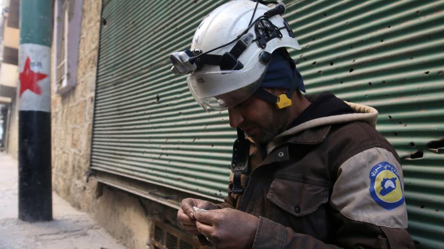 A Civil Defence member rolls a cigarette in a rebel-held area of Aleppo, Syria December 8, 2016. REUTERS/Abdalrhman Ismail - RC153EB0CE80