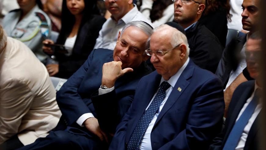 Israeli Prime Minister Benjamin Netanyahu chats with Israeli President Reuven Rivlin during a memorial ceremony for Israeli soldiers killed in the 1973 Middle East War at Mount Herzl Military Cemetery in Jerusalem October 10, 2019. REUTERS/Ronen Zvulun - RC1B94342680