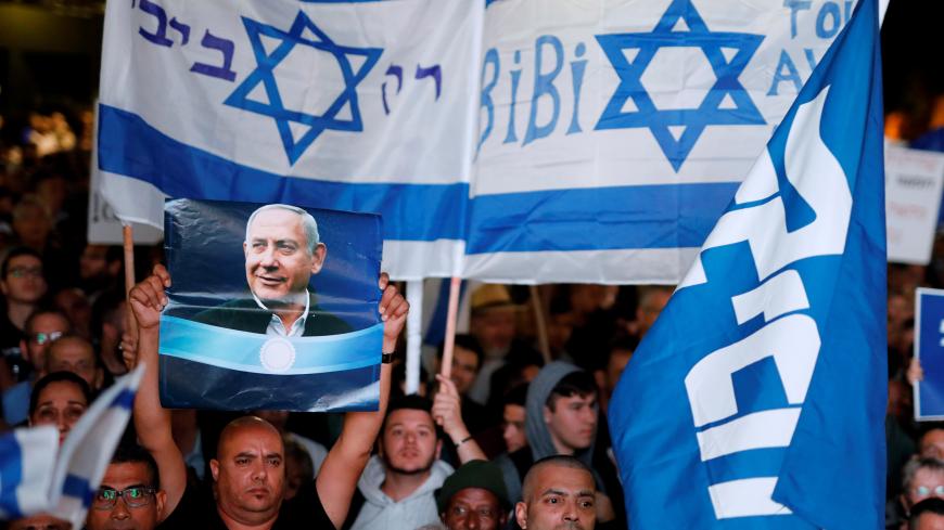 Supporters of Israeli Prime Minister Benjamin Netanyahu take part in a protest supporting Netanyahu after he was charged in corruption cases, in Tel Aviv, Israel November 26, 2019. The words in Hebrew read "Only Bibi". REUTERS/Amir Cohen - RC28JD93UD89