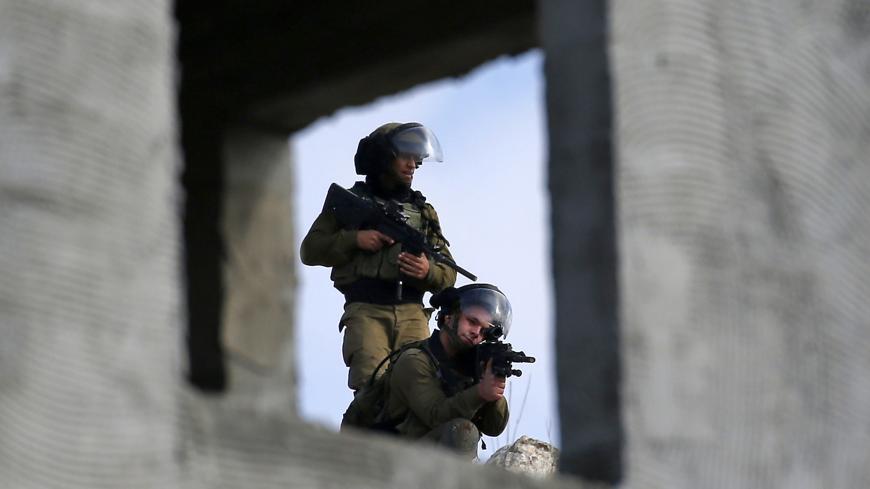 An Israeli soldier looks through the scope of his rifle during clashes with Palestinian demonstrators following a weekly protest against the expropriation of Palestinian land by Israel, in the village of Kfar Qaddum, in the occupied West Bank on December 6, 2019. (Photo by JAAFAR ASHTIYEH / AFP) (Photo by JAAFAR ASHTIYEH/AFP via Getty Images)