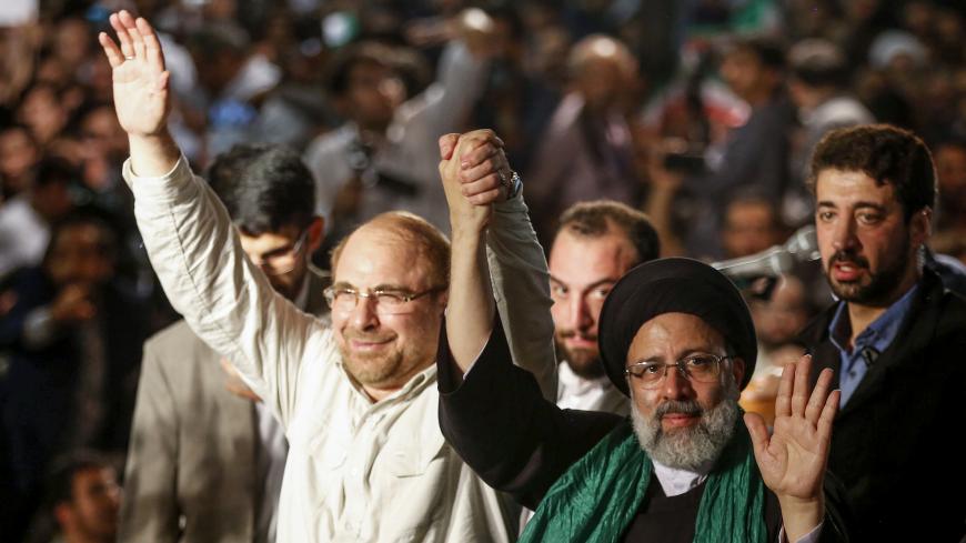 Iranian presidential candidate Ebrahim Raisi (R-2) holds hands with former presidential candidate and mayor of Tehran, Mohammad Bagher Ghalibaf (L), as he greets his supporters during a campaign rally at Imam Khomeini Mosque in the capital Tehran on May 16, 2017.
Iran's presidential election on May 19 is effectively a choice between moderate incumbent Hassan Rouhani and hardline jurist Raisi, with major implications for everything from civil rights to relations with Washington. / AFP PHOTO / ATTA KENARE    