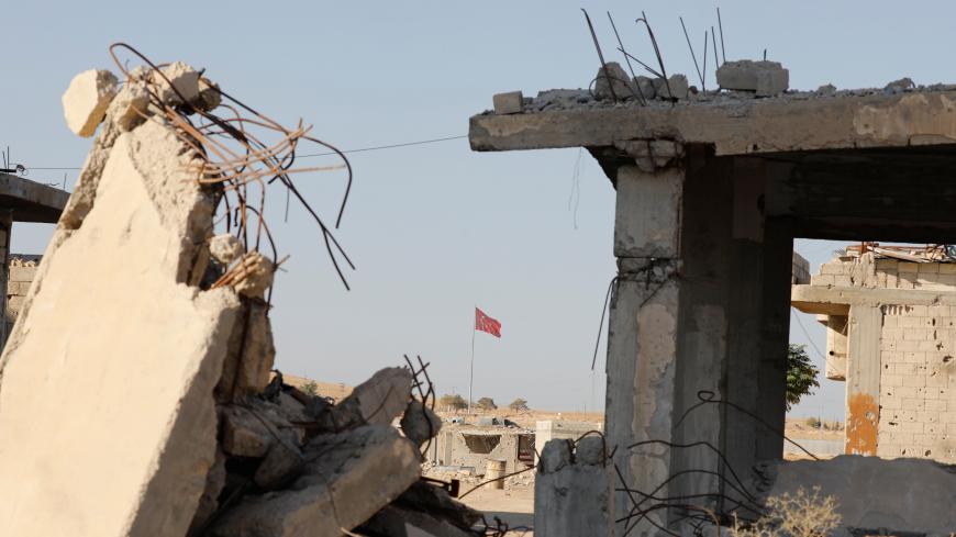 Turkish flag flutters at Turkey's border gate, as pictured on Syria side, overlooking the ruins of buildings destroyed during fightings with the Islamic State militants in Kobani, Syria October 11, 2017. Picture taken October 11, 2017.    REUTERS/Erik De Castro - RC1E48BC4870