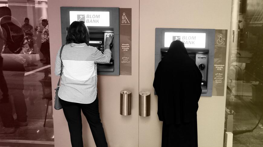Women use ATMs at Blom bank in Beirut, Lebanon November 1, 2019. Picture taken through glass. REUTERS/Goran Tomasevic - RC1F45458210