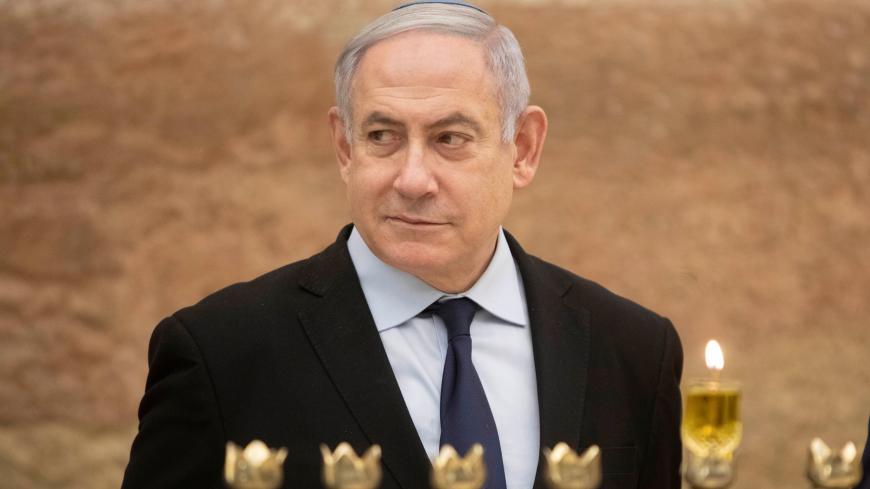 Israeli Prime Minister Benjamin Netanyahu looks on after lighting a Hanukkah candle at the Western Wall, the holiest site where Jews can pray in Jerusalem's old city, December 22, 2019. Sebastian Scheiner/Pool via REUTERS - RC2I0E9GDB8Y