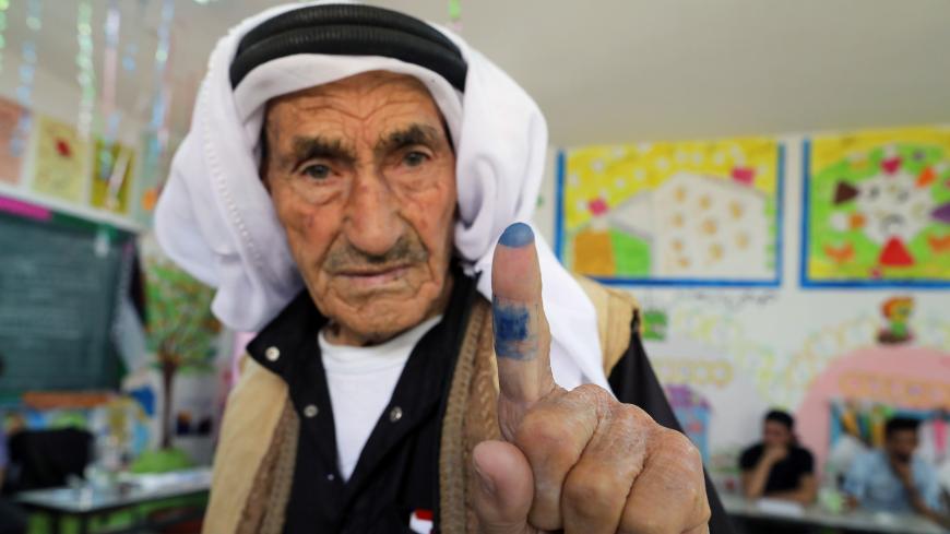 A Palestinian man shows his ink-stained finger after casting his ballot at a polling station during municipal elections in the West Bank village of Yatta, near Hebron May 13, 2017. REUTERS/Ammar Awad - RC19806991C0