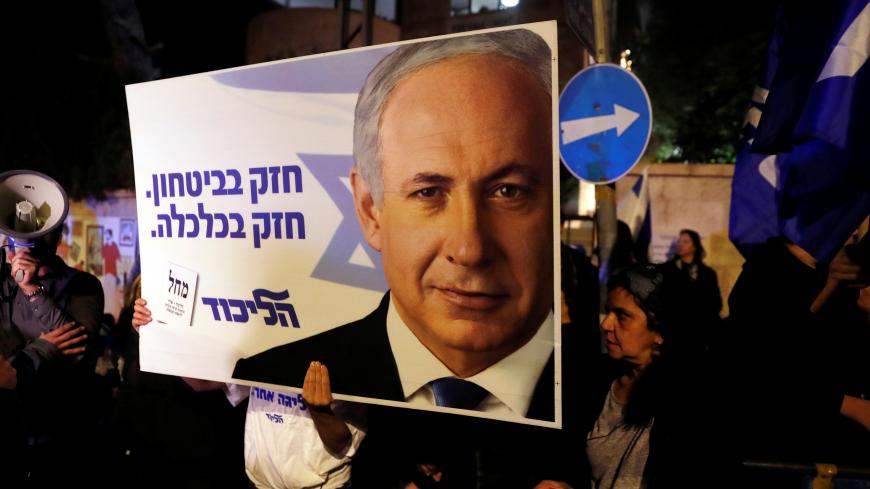 Supporters of Israeli Prime Minister Benjamin Netanyahu protest outside his residence following Israel's Attorney General Avichai Mandelblit's indictment ruling in Jerusalem November 21, 2019. The placards in Hebrew read, "Strong in security Strong in Economy ". REUTERS/Ronen Zvulun - RC2UFD9PGBE1