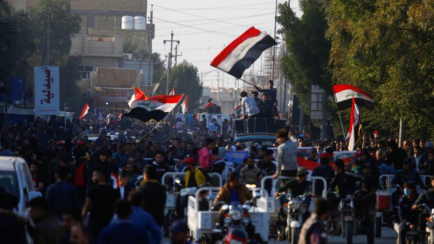 Iraqi demonstrators carry pictures of people who were killed during ongoing anti-government protests in Nassiriya, Iraq December 4, 2019. Picture taken December 4, 2019. REUTERS/Alaa al-Marjani - RC2MPD9WP3M6