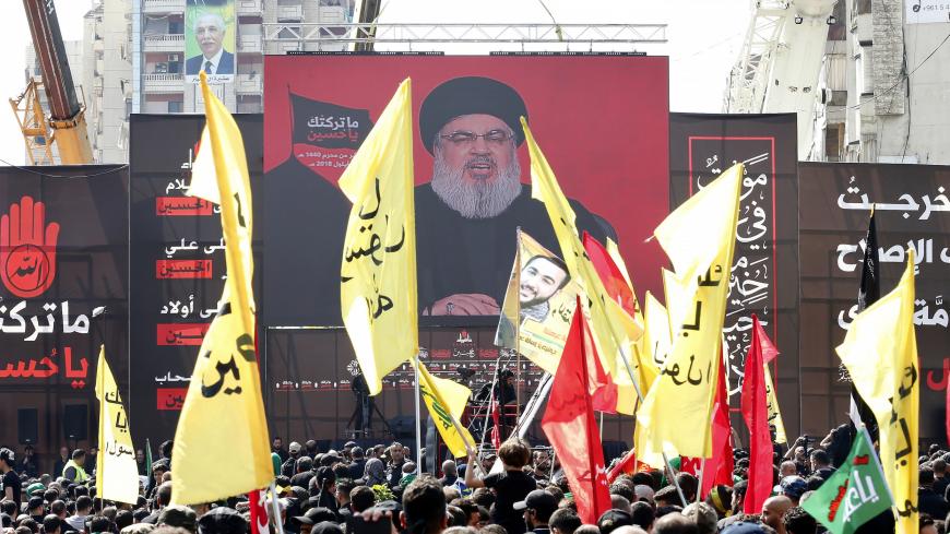 Supporters of Lebanon's Shiite movement Hezbollah gather near a giant poster of their leader Hassan Nasrallah during a ceremony to mark Ashura on September 20, 2018 in Beirut. - Ashura commemorates the death of Imam Hussein, grandson of the Muslim faith's prophet Mohammed, who was killed by the armies of his rival Yazid over the succession for the caliphate near Karbala in 680 AD. (Photo by ANWAR AMRO / AFP)        (Photo credit should read ANWAR AMRO/AFP/Getty Images)