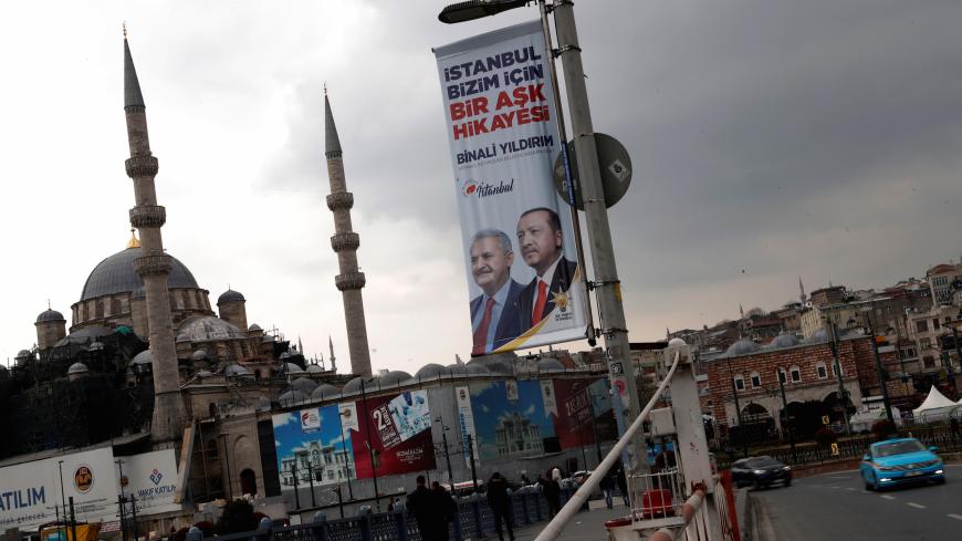 An election banner with the pictures of Turkish President Tayyip Erdogan and AK Party mayoral candidate Binali Yildirim is seen over the Galata bridge in Istanbul, Turkey, March 27, 2019. The slogan on the banner reads that: "Istanbul is a love story for us". REUTERS/Murad Sezer - RC1F13574C10