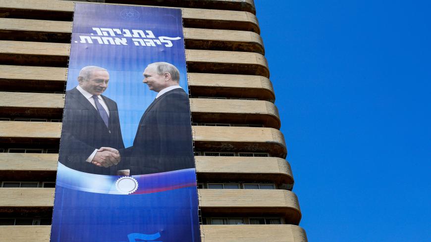 This picture taken on July 28, 2019 shows two giant Israeli Likud Party election banners hanging from a building showing Israeli Prime Minister Benjamin Netanyahu shaking hands with Russian President Vladimir Putin, with a caption above reading in Hebrew "Netanyahu, in another league", in the coastal Mediterranean city of Tel Aviv. (Photo by JACK GUEZ / AFP)        (Photo credit should read JACK GUEZ/AFP via Getty Images)