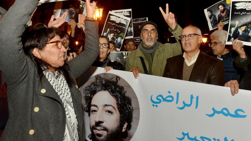 Demonstrators shoot slogans and hold a banner showing a portrait of Omar Radi, a Moroccan journalist detained over tweet criticising judge, during a demonstration, on December 28, 2019, in the city of Rabat. (Photo by STR / AFP) (Photo by STR/AFP via Getty Images)