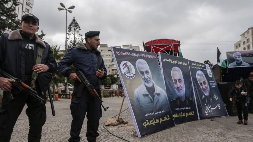 Hamas policemen in Gaza City stand guard during a mourning ceremony organised in honour of slain Iranian military commander Qasem Soleimani (portrait) killed in the Iraqi capital Baghdad in a US air strike a day earlier, on January 4, 2020. (Photo by MAHMUD HAMS / AFP) (Photo by MAHMUD HAMS/AFP via Getty Images)