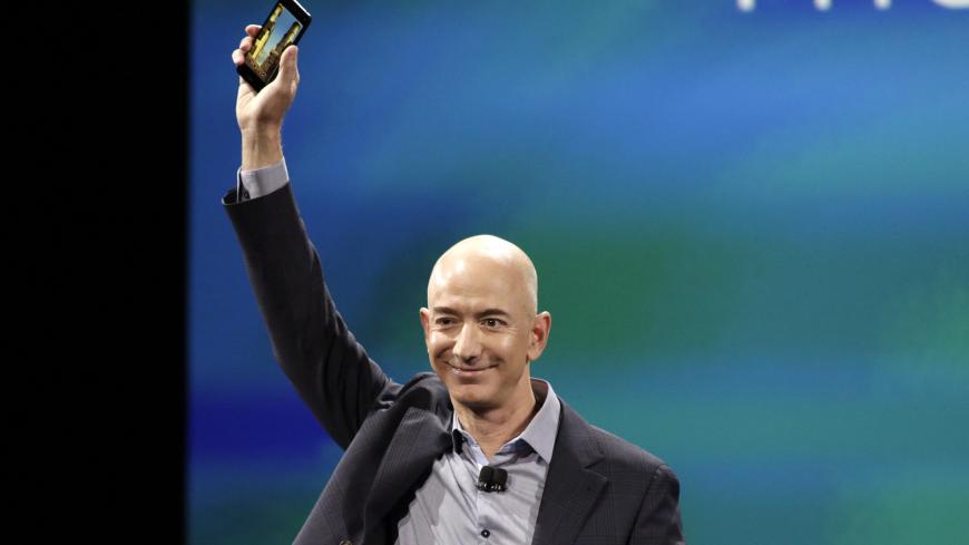 Amazon CEO Jeff Bezos shows off his company's new smartphone, the Fire Phone, at a news conference in Seattle, Washington June 18, 2014.  REUTERS/Jason Redmond  (UNITED STATES - Tags: SCIENCE TECHNOLOGY BUSINESS TPX IMAGES OF THE DAY) - GM1EA6J06CN02
