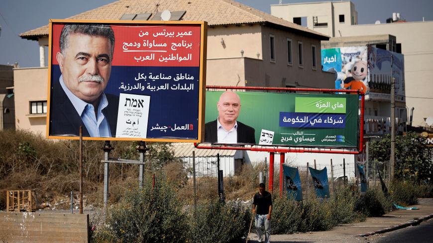 A Labour party election banner depicting party leader Amir Peretz and writing in Arabic reading "industrial areas in all Arab and Druze cities" is seen next to another election banner depicting Issawi Frej, an Arab politician in the left-wing Meretz party with Arabic writing that reads "This time we will participate in government", in Tira, northern Israel September 5, 2019. Picture taken September 5, 2019. REUTERS/Amir Cohen - RC1C5F38BCB0