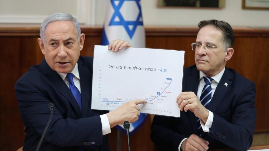 Israeli Prime Minister Benjamin Netanyahu and Cabinet Secretary Tzahi Braverman present an investment chart during the weekly cabinet meeting in Jerusalem, Israel, December 29, 2019. Abir Sultan/Pool via REUTERS - RC2Z4E91TD9X