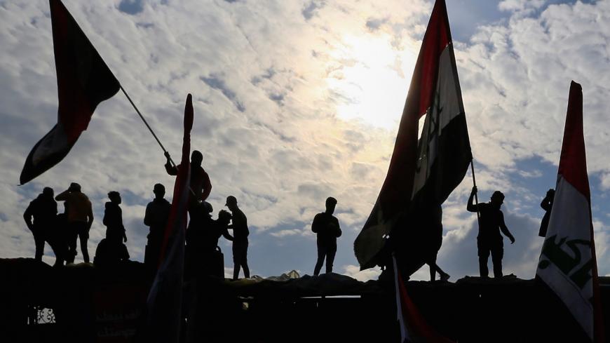 Iraqi demonstrators carry Iraqi flags during ongoing anti-government protests in Baghdad, Iraq January 10, 2020. REUTERS/Thaier al-Sudani - RC21DE9AHHEQ