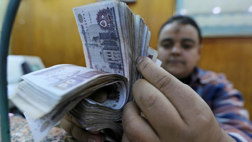 An employee counts Egyptian pounds in a foreign exchange office in central Cairo, Egypt December 27, 2016. REUTERS/Mohamed Abd El Ghany - RC1A38C79D70