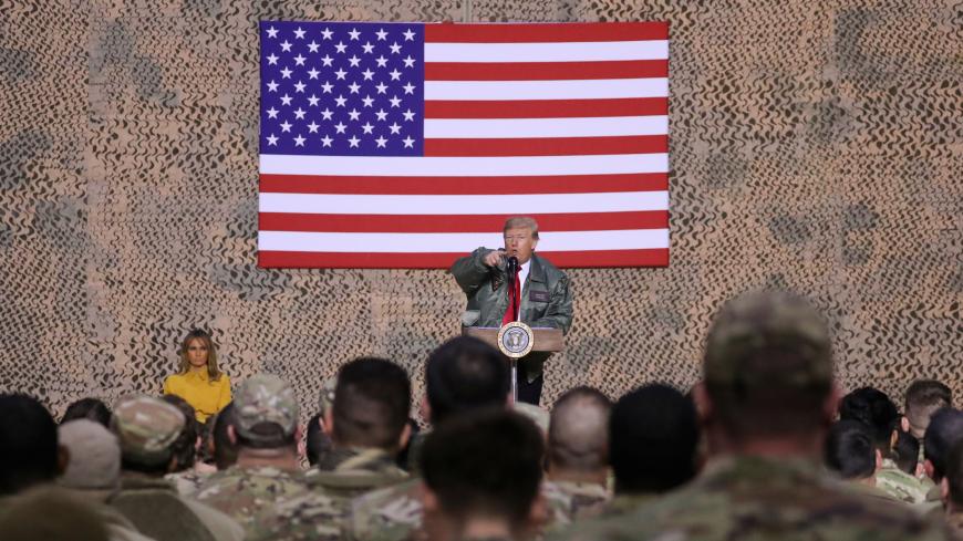 U.S. President Donald Trump, with first lady Melania Trump, delivers remarks to U.S. troops in an unannounced visit to Al Asad Air Base, Iraq, December 26, 2018. REUTERS/Jonathan Ernst - RC1B49CC86F0
