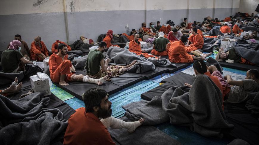 Men, suspected of being affiliated with the Islamic State (IS) group, gather in a prison cell in the northeastern Syrian city of Hasakeh on October 26, 2019. - Kurdish sources say around 12,000 IS fighters including Syrians, Iraqis as well as foreigners from 54 countries are being held in Kurdish-run prisons in northern Syria. (Photo by FADEL SENNA / AFP) (Photo by FADEL SENNA/AFP via Getty Images)