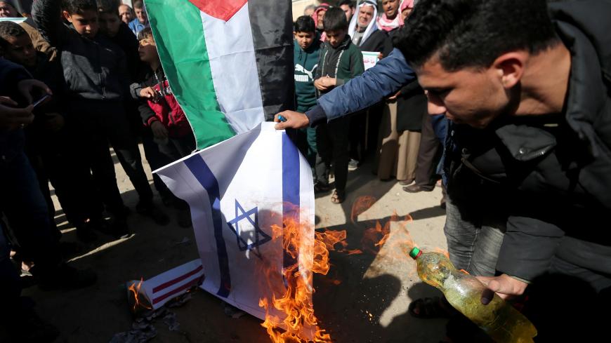Palestinian demonstrators burn a representation of an Israeli flag during a protest against the U.S. President Donald Trump's Middle East peace plan, in the southern Gaza Strip January 31, 2020. REUTERS/Ibraheem Abu Mustafa - RC2ZQE9RWL7X