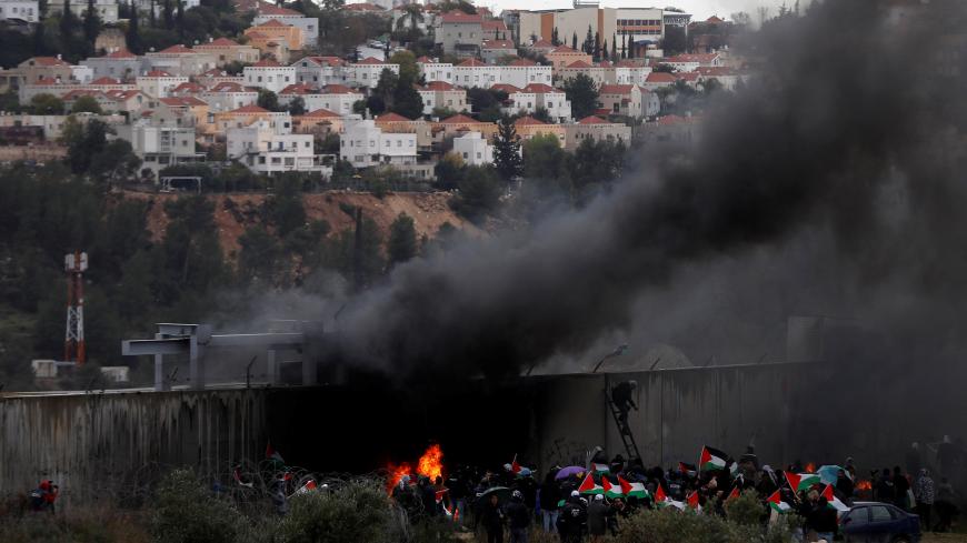 Palestinian demonstrators gather near the Israeli barrier in the village of Bilin as the Jewish settlement of Modiin Illit is seen in the background, in the Israeli-occupied West Bank February 7, 2020. REUTERS/Mohamad Torokman - RC2NVE9EZDCB