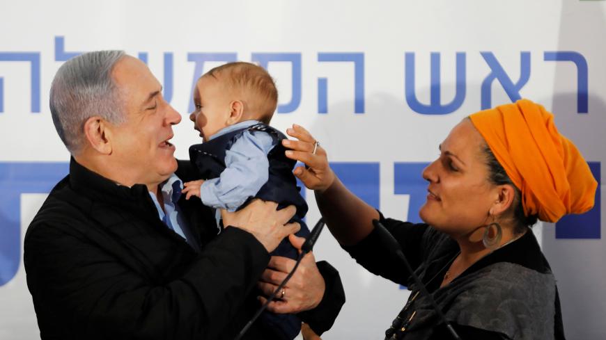 Israeli Prime Minister Benjamin Netanyahu holds a baby during an event marking Tu BiShvat, the Jewish Arbor Day, in the Israeli settlement of Mevo'ot Yericho, in the Israeli-occupied West Bank February 10, 2020. REUTERS/Nir Elias - RC2RXE94OAAK