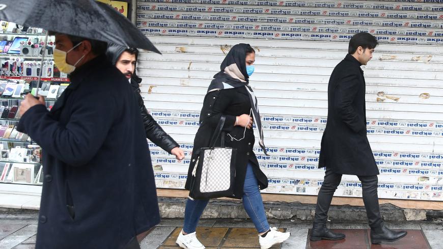 Iranian people wear protective masks to prevent contracting coronavirus, as they walk in the street in Tehran, Iran February 25, 2020. WANA (West Asia News Agency)/Nazanin Tabatabaee via REUTERS ATTENTION EDITORS - THIS IMAGE HAS BEEN SUPPLIED BY A THIRD PARTY. - RC2P7F9O2XY3