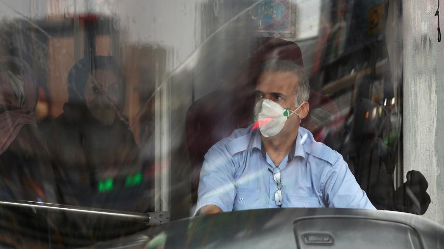 A bus driver wears protective a mask to prevent contracting coronavirus, as he drives the bus in Tehran, Iran February 25, 2020. WANA (West Asia News Agency)/Nazanin Tabatabaee via REUTERS ATTENTION EDITORS - THIS IMAGE HAS BEEN SUPPLIED BY A THIRD PARTY. - RC2Q7F9BMNO8