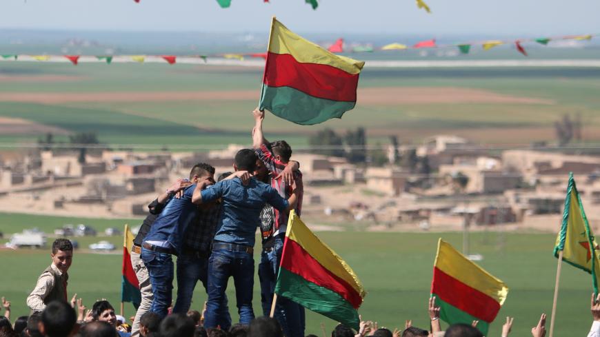 Kurdish people carry flags as they celebrate the spring festival of Nowruz, in al-Darbasiyah town, on the Syrian-Turkish border, Syria March 21, 2017. REUTERS/Rodi Said - RC1F25CCC510