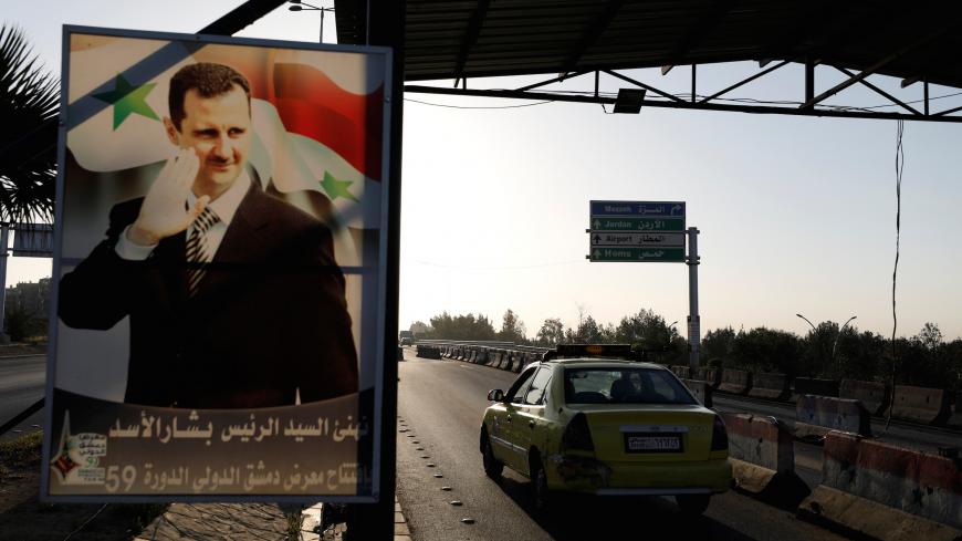 A poster of Syrian President Bashar al-Assad is seen on the main road to the airport in Damascus, Syria April 14, 2018. REUTERS/Omar Sanadiki - RC138B3674B0