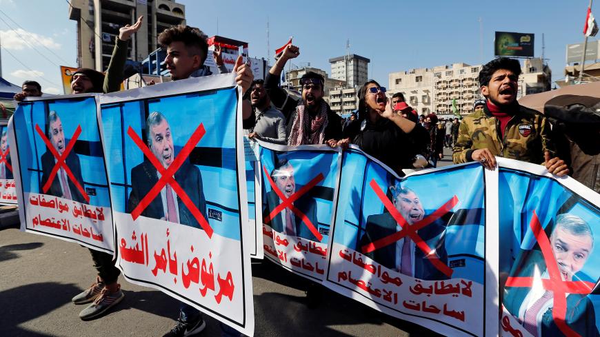Iraqi demonstrators and university students carry posters depicting the newly appointed Prime Minister of Iraq, Mohammed Tawfiq Allawi, to express their rejection of him, during ongoing anti-government protests in Baghdad, Iraq February 2, 2020. REUTERS/Wissm al-Okili - RC2CSE9SET8I