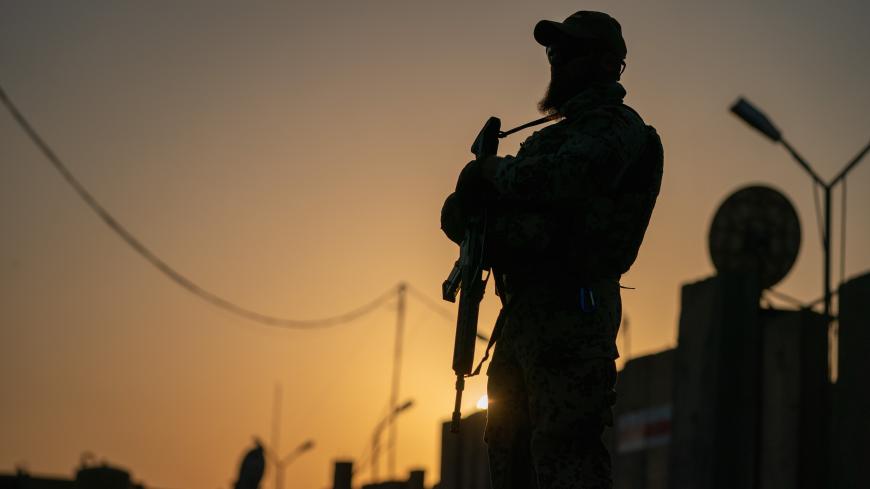 20 August 2019, Iraq, Bagdad: A soldier of the German Armed Forces is standing at dusk with his weapon on the verge of the German Defence Minister's visit to the international military camp Camp Taji. The minister and CDU leader is conducting political talks in the capital Baghdad and is meeting German soldiers who are involved in training local forces in the country. Photo: Michael Kappeler/dpa (Photo by Michael Kappeler/picture alliance via Getty Images)