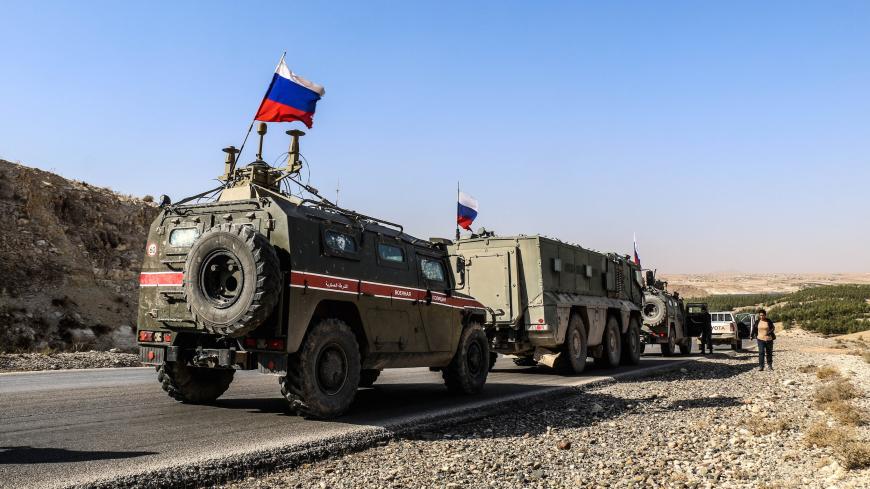 ALEPPO, SYRIA - NOVEMBER 18: Russian soldiers, with Russian flag, are seen on armoured vehicle as they enter the base at the Tishrin Dam on the Euphrates, which the US troops' withdrew from, located 90 kilometres east of Aleppo in Aleppo Governorate, Syria on November 18, 2019. (Photo by Bekir Kasim/Anadolu Agency via Getty Images)