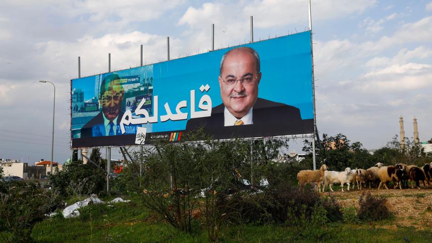 A picture taken on February 21, 2020, shows a portrait of PM Netanyahu (Left) and portrait of Arab Israeli member of the Joint List Ahmad Tibi (R) on a campaign poster, with Arabic writing reading "staying here" as a response to Netanyahu's Likud party campaign pledging for a government "without Ahmad Tibi", in the northern Israeli City of Tayyiba. (Photo by AHMAD GHARABLI / AFP) (Photo by AHMAD GHARABLI/AFP via Getty Images)