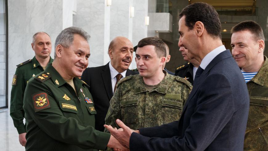 DAMASCUS, SYRIA - MARCH 23, 2020: Russia's Defence Minister Sergei Shoigu and Syria's President Bashar al-Assad (L-R front) shake hands during a meeting. Vadim Savitsky/Russian Defence Ministry Press Office/TASS (Photo by Vadim Savitsky\TASS via Getty Images)