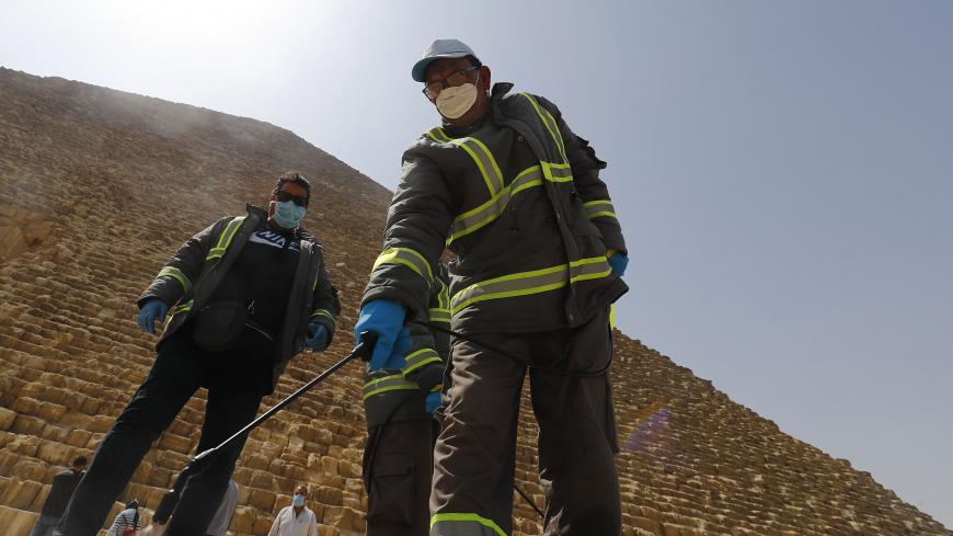 Egyptian municipality workers disinfect the Giza pyramids necropolis on the southwestern outskirts of the Egyptian capital Cairo on March 25, 2020 as protective a measure against the spread of the coronavirus COVID-19. (Photo by Khaled DESOUKI / AFP) (Photo by KHALED DESOUKI/AFP via Getty Images)