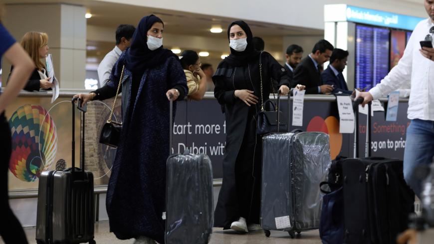 Travellers wear masks as they arrive at the Dubai International Airport, after the UAE's Ministry of Health and Community Prevention confirmed the country's first case of coronavirus, in Dubai, United Arab Emirates January 29, 2020. REUTERS/Christopher Pike - RC2LPE9ORR0A