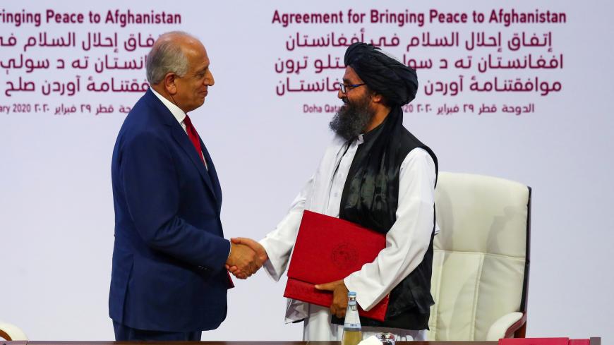 Mullah Abdul Ghani Baradar, the leader of the Taliban delegation, and Zalmay Khalilzad, U.S. envoy for peace in Afghanistan, shake hands after signing an agreement at a ceremony between members of Afghanistan's Taliban and the U.S. in Doha, Qatar February 29, 2020. REUTERS/Ibraheem al Omari - RC2LAF91DVTE