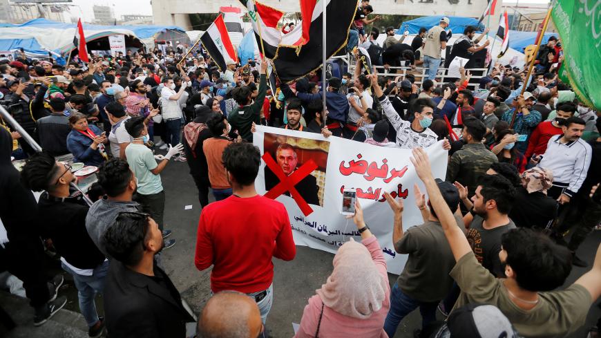 Iraqi demonstrators carry a poster depicting the Prime Minister of Iraq, Mohammed Tawfiq Allawi, to express their rejection of him, during ongoing anti-government protests in Baghdad, Iraq March 1, 2020. REUTERS/Wissam al-Okaili - RC21BF9IG5VT