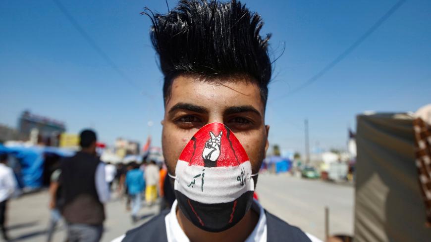 A student wears a protective face mask, following the outbreak of the new coronavirus, as he poses for a photo during ongoing anti-government protests in Basra, Iraq March 5, 2020. REUTERS/Essam al-Sudani - RC2LDF9G22Z3
